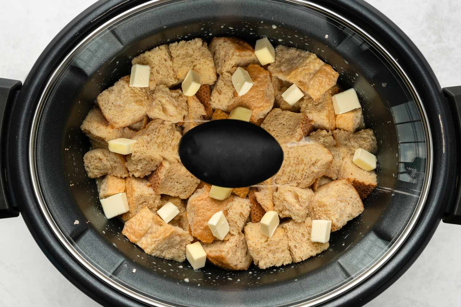 Crock pot French toast cooking with butter cubes