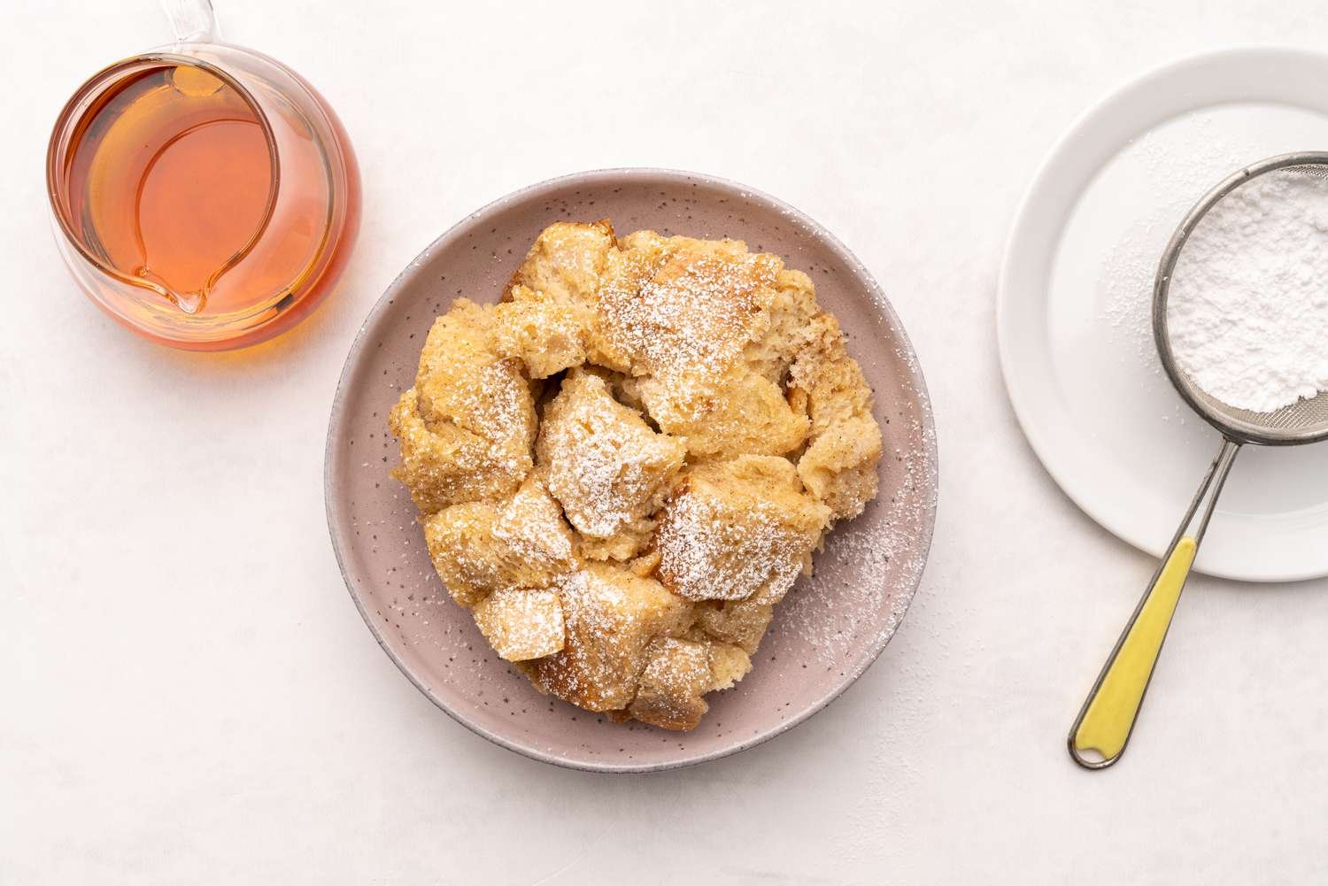 Plate of crock pot French toast with confectioners' sugar and maple syrup