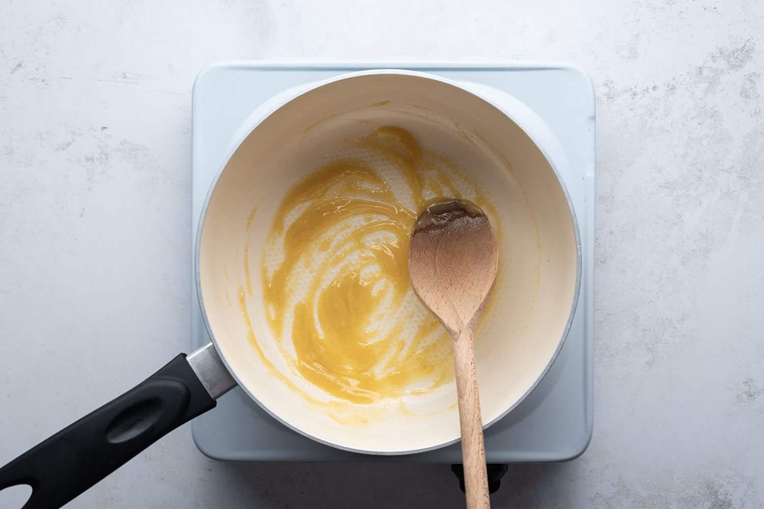 Flour and butter mixture in a saucepan with a wooden spoon, on a burner