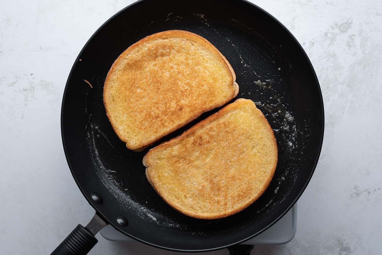 Sandwiches in a pan on a burner