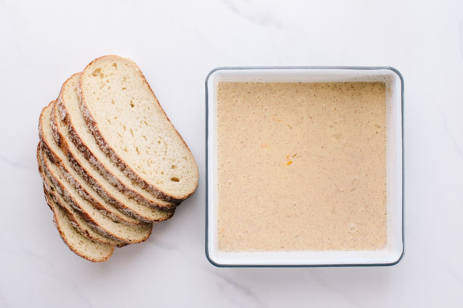 Sourdough bread and French toast batter in a dish