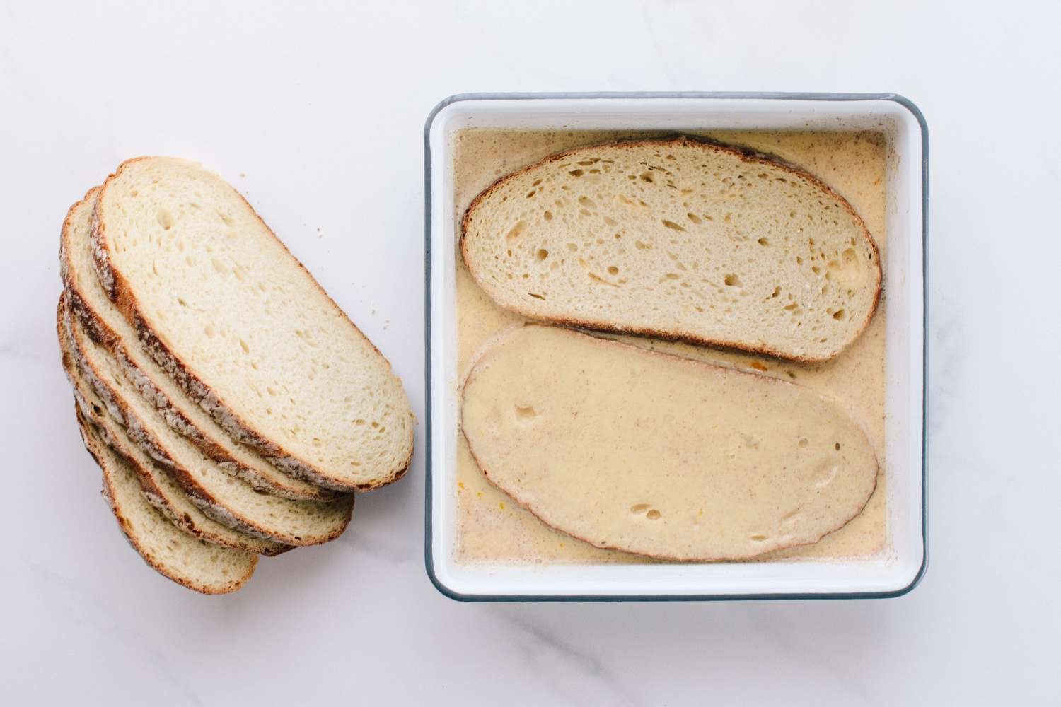 Sourdough bread slices soaking in French toast batter