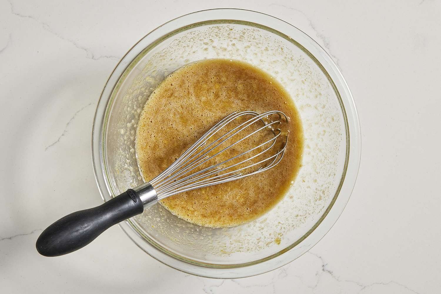 wet ingredients for pumpkin banana bread in bowl with whisk