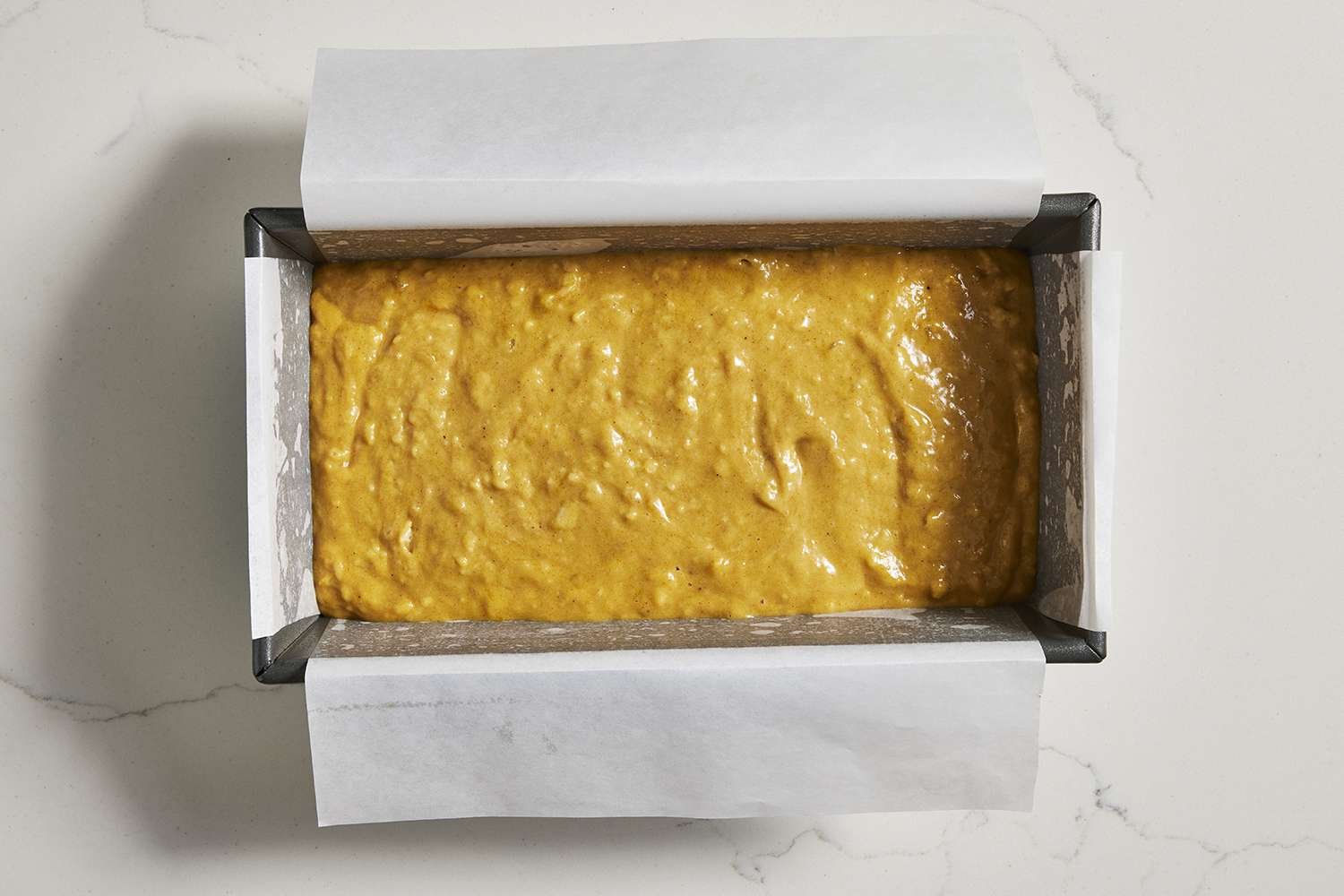 loaf pan filled with pumpkin banana bread batter