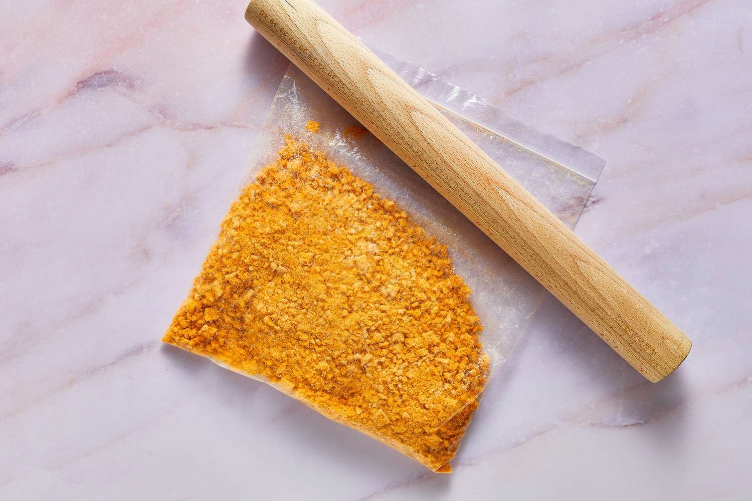 A rolling pin and a freezer bag filled with crushed Cap'n Crunch cereal