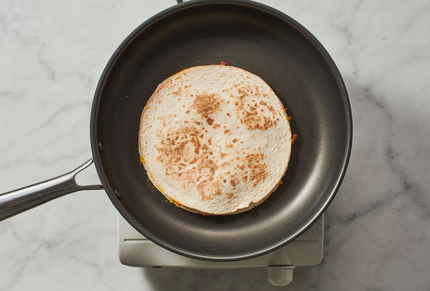 A cheese quesadilla in a skillet