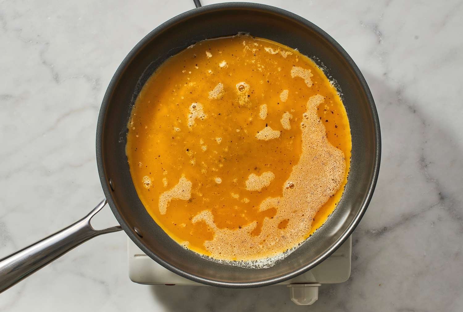 A pan with raw, beaten eggs