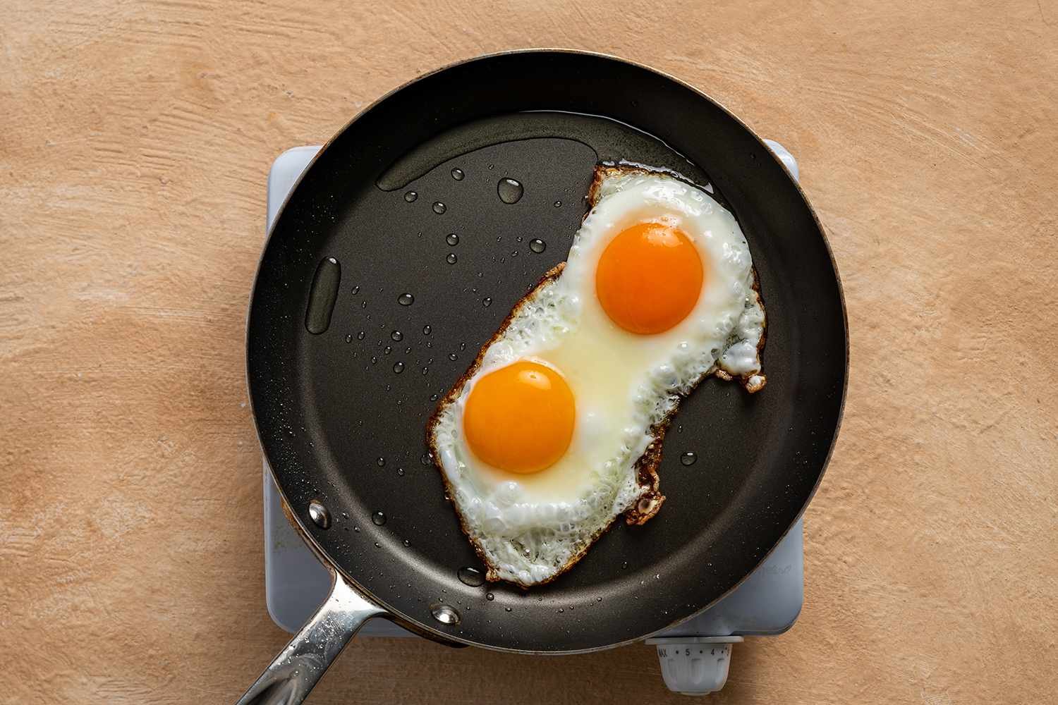 Eggs cooking in a pan on a burner 