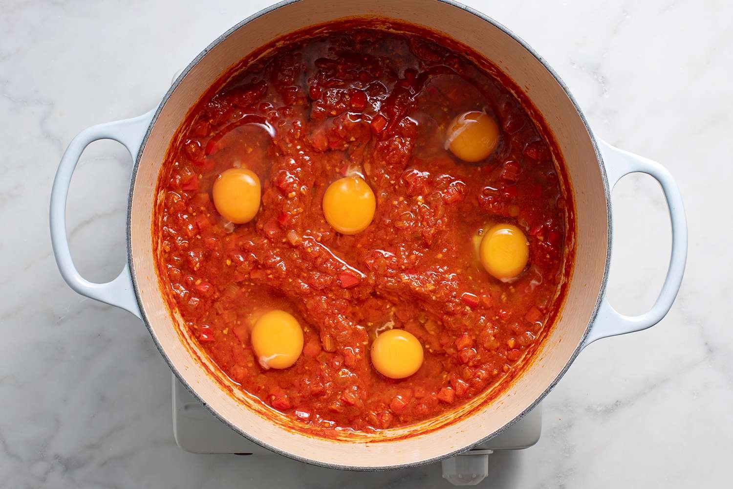 Eggs in the tomato sauce in a pot