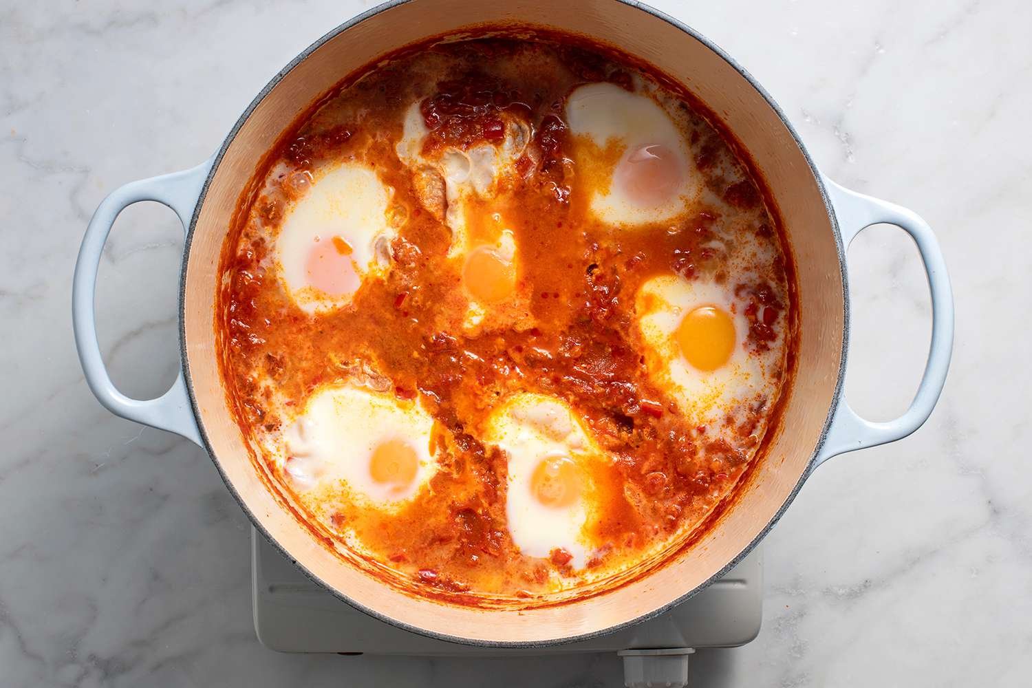 Eggs cooking in the tomato sauce in a pot