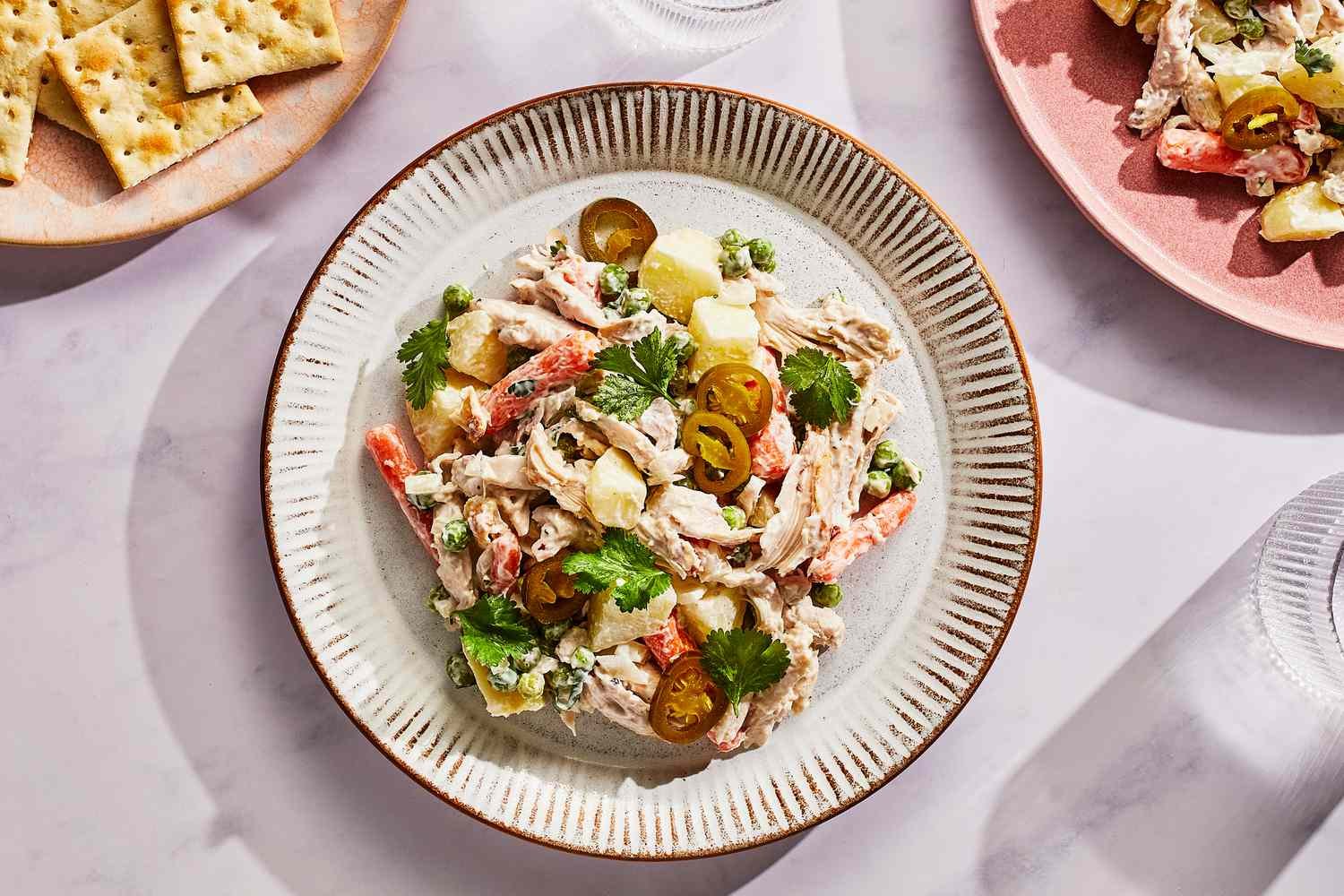 A plate of Mexican chicken salad, served with pickled jalapeños and crackers