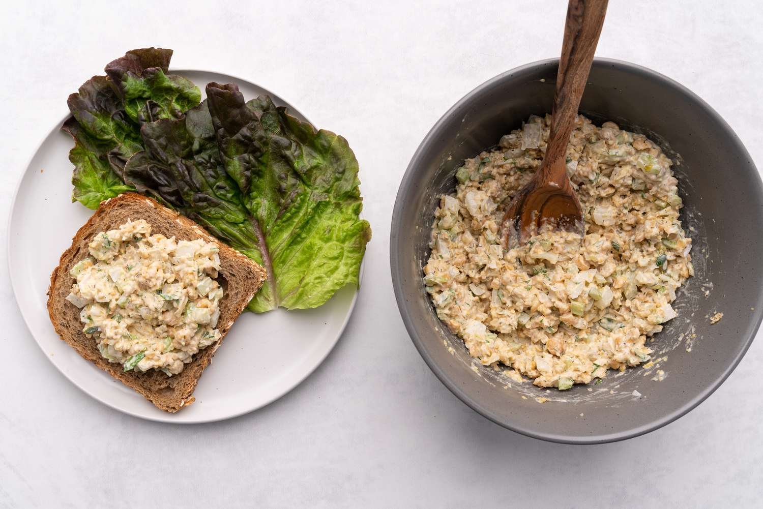 Vegan chickpea tuna salad in a bowl and spread on a slice of bread