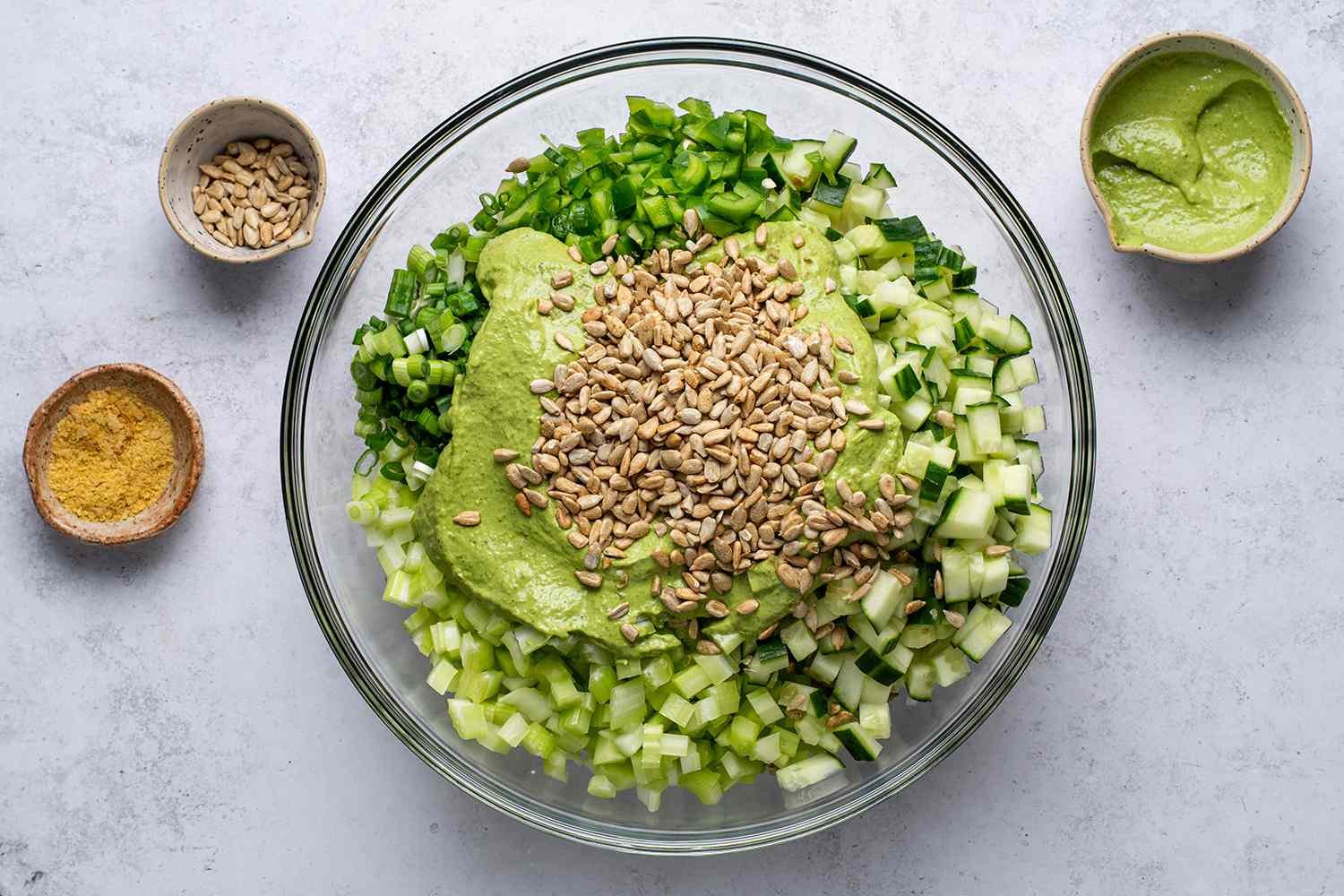 Green goddess salad topped with dressing and sunflower seeds