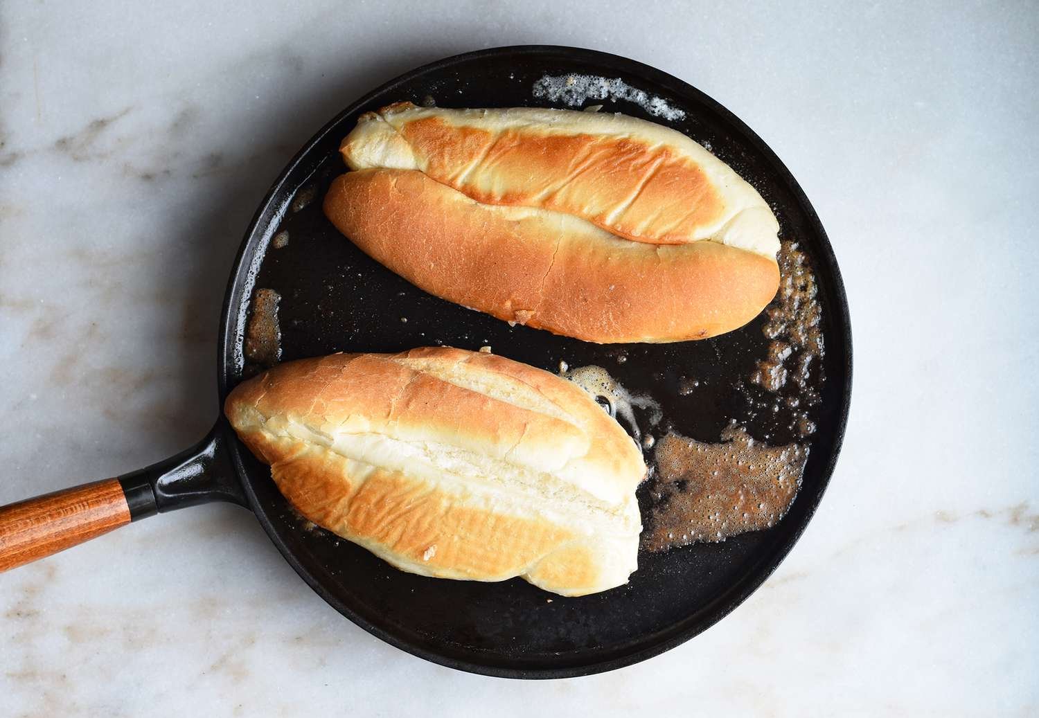 Hoagie rolls grilled in a buttered pan