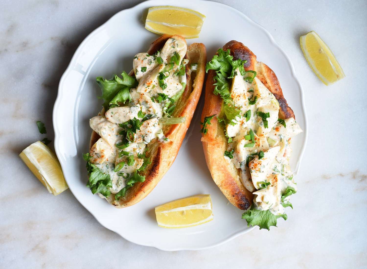 Vegan lobster rolls with lettuce and lemon wedges